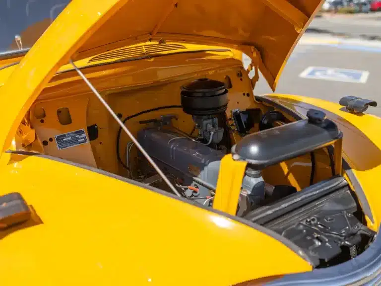 Blick in den Motorraum eines restaurierten Nash Model 3248 Schulbusses von 1949 mit aufgeklappter gelber Haube.