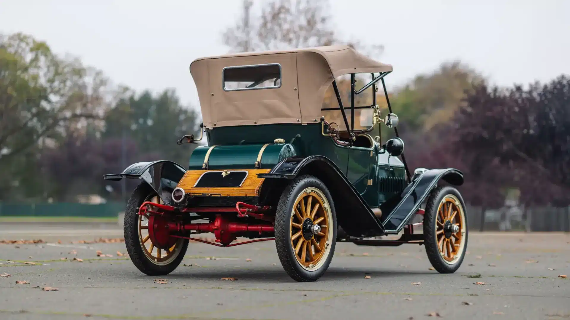 Der Herreshoff Model 30 Runabout von 1913 mit grünem Lack, Holzspeichenrädern und offenem Verdeck, fotografiert von hinten.
