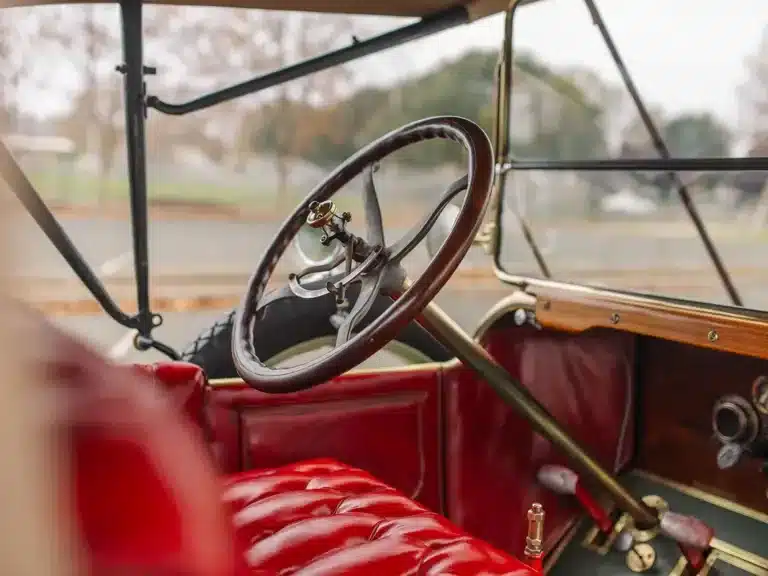 Detailaufnahme des Innenraums mit Lenkrad und roter Lederbank im Herreshoff Model 30 Runabout von 1913.