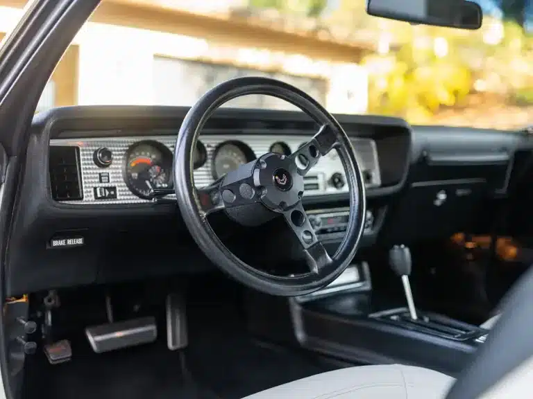 Innenraum und Armaturenbrett eines Pontiac Trans Am SD-455 aus dem Jahr 1974, Fokus auf Lenkrad und Instrumente.