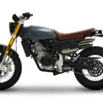 Fantic Caballero 125 Deluxe in Seitenansicht mit schiefergrauem Tank, brauner Sitzbank und markanter Scrambler-Optik