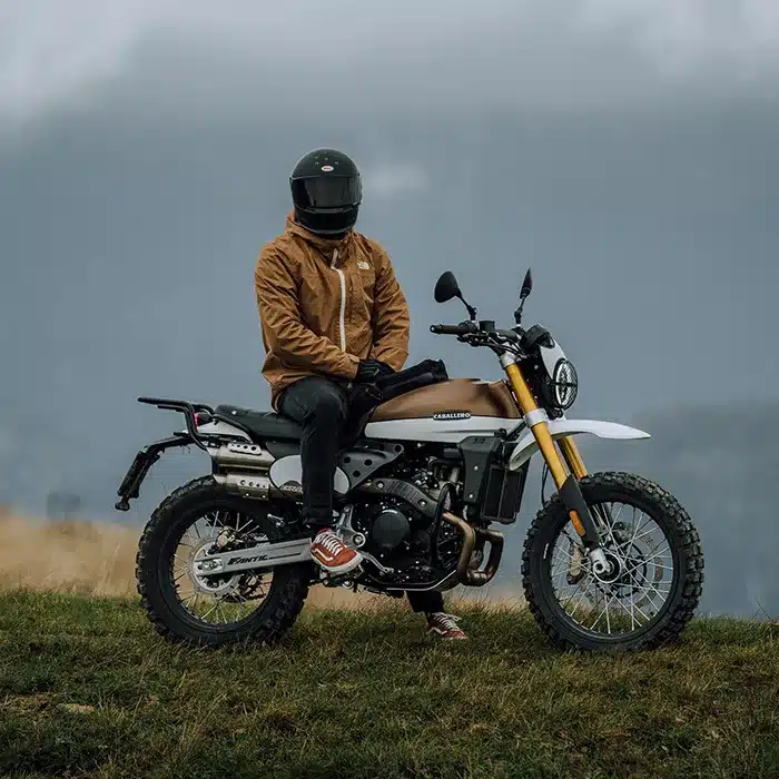 Fantic Caballero 500 Scrambler mit Fahrer im Outdoor-Einsatz auf Wiese