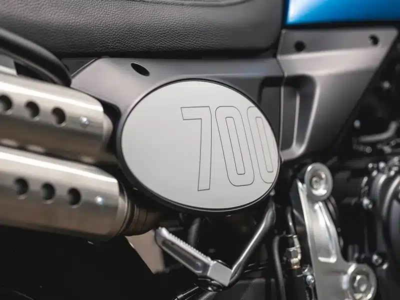 Nahaufnahme des seitlichen Emblems und Auspuffs einer Fantic Caballero 700