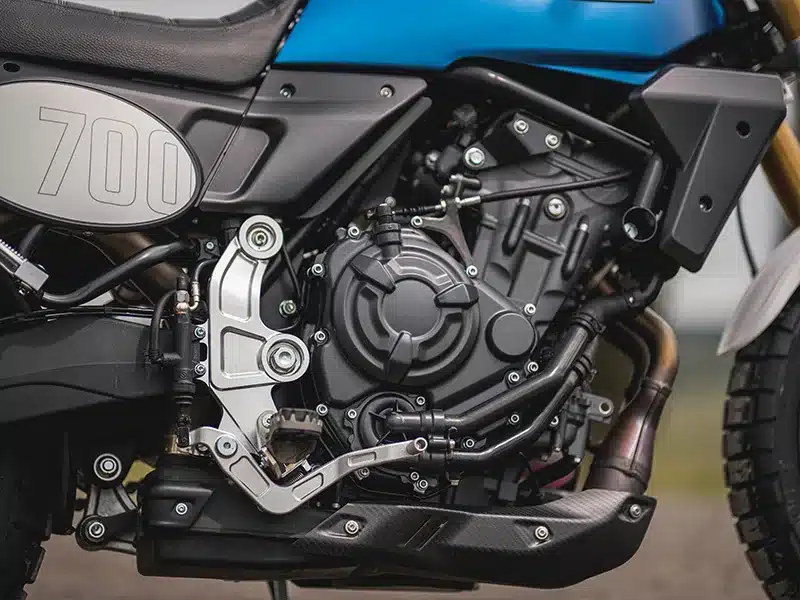 Nahaufnahme des Motors und Rahmens der Fantic Caballero 700 mit Sicht auf Zylinder, Schwinge und Tankbereich.