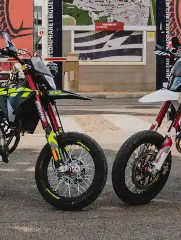 Fantic XM 50 Competition und XMF 125 Competition 2025 nebeneinander vor Messekulisse