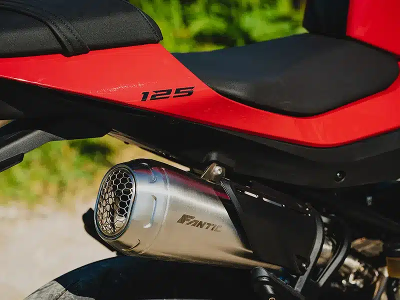 Nahaufnahme vom Auspuff, Sitzbank und Seitenteil der Fantic Stealth 125 in Rot