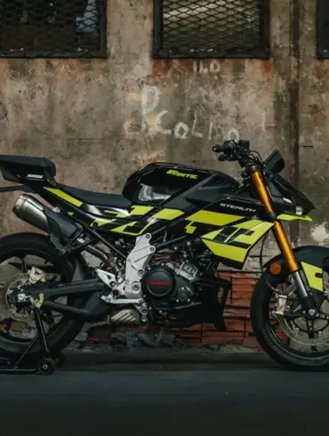 Seitenansicht der Fantic Stealth 125 in Acid Green vor einer Industrie-Mauer
