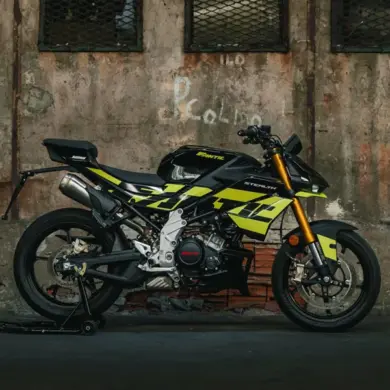 Seitenansicht der Fantic Stealth 125 in Acid Green vor einer Industrie-Mauer