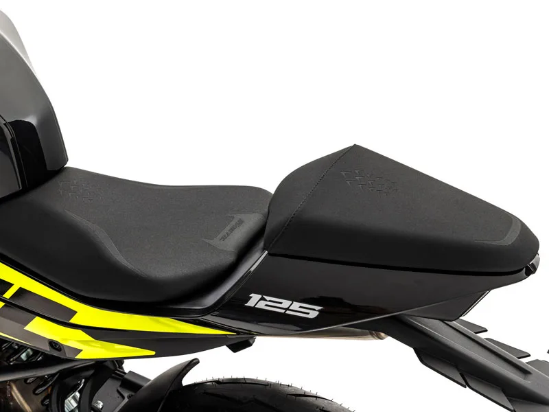 Detailaufnahme des Einzelsitzes der Fantic Stealth 125 in Acid Green mit markanter Verkleidung und 125er-Schriftzug.