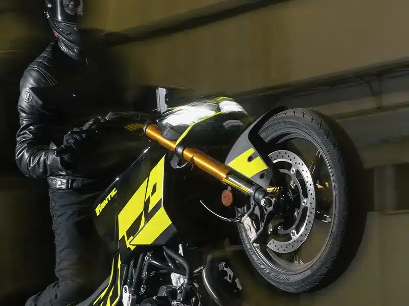 Motorrad Fantic Stealth 500 Acid Green in auffälliger Lackierung, frontal bei Fahrt im Dunkeln