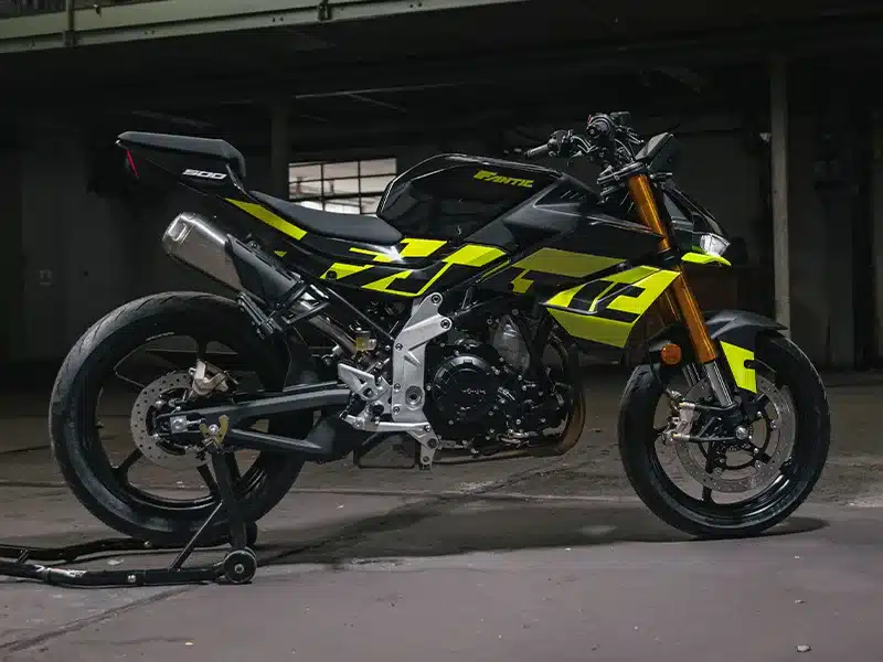 Seitenansicht der Fantic Stealth 500 Acid Green aufgebockt in einer dunklen Halle, sportliches Naked Bike mit auffälligen neongrünen Grafikelementen.