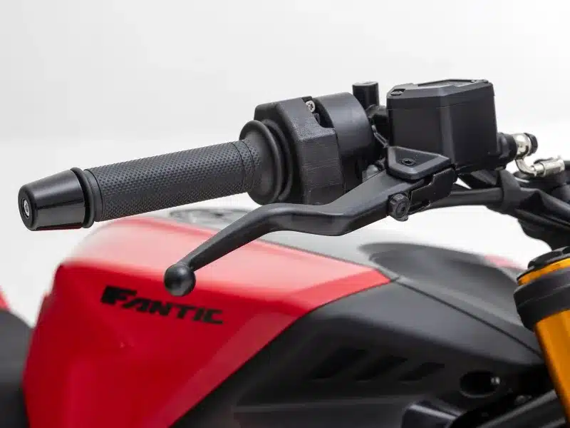 Nahaufnahme vom Lenker und Bremshebel einer Fantic Stealth 500 mit rotem Tank