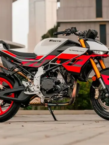 Fantic Stealth 500 Racing White Motorrad in Racing White mit roten Details, seitlich fotografiert vor moderner Kulisse.