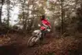 Enduro-Fahrer auf der neuen Fantic XEF 250 (2026) fährt dynamisch durch einen herbstlichen Waldweg