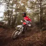 Enduro-Fahrer auf der neuen Fantic XEF 250 (2026) fährt dynamisch durch einen herbstlichen Waldweg