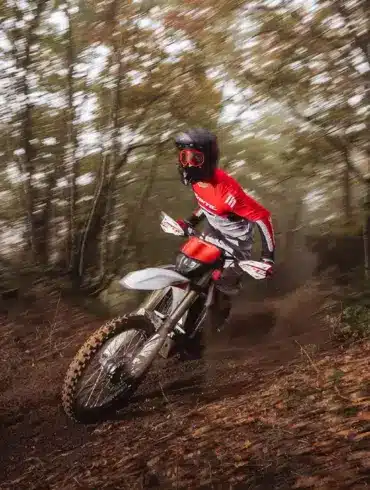 Enduro-Fahrer auf der neuen Fantic XEF 250 (2026) fährt dynamisch durch einen herbstlichen Waldweg