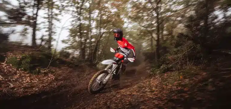 Enduro-Fahrer auf der neuen Fantic XEF 250 (2026) fährt dynamisch durch einen herbstlichen Waldweg