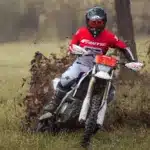 Ein Fahrer bewegt die Fantic XEF 450 durch schlammiges Gelände, spritzt Erde auf und demonstriert die Offroad-Fähigkeiten des Motorrads.