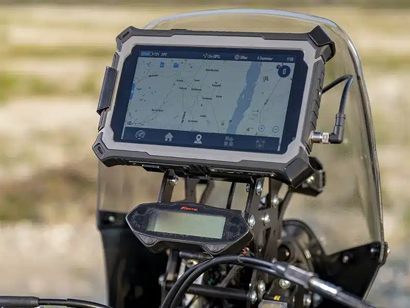 Nahaufnahme des robusten 7-Zoll-RallyScreen-Displays der Fantic XEF Rally 2025 mit Navigationsanzeige auf dem Motorrad-Cockpit.