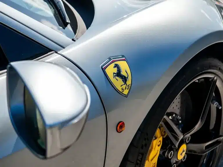 Detailfoto des vorderen Kotflügels eines Ferrari 458 Speciale in Grau mit Ferrari-Emblem und gelbem Bremssattel