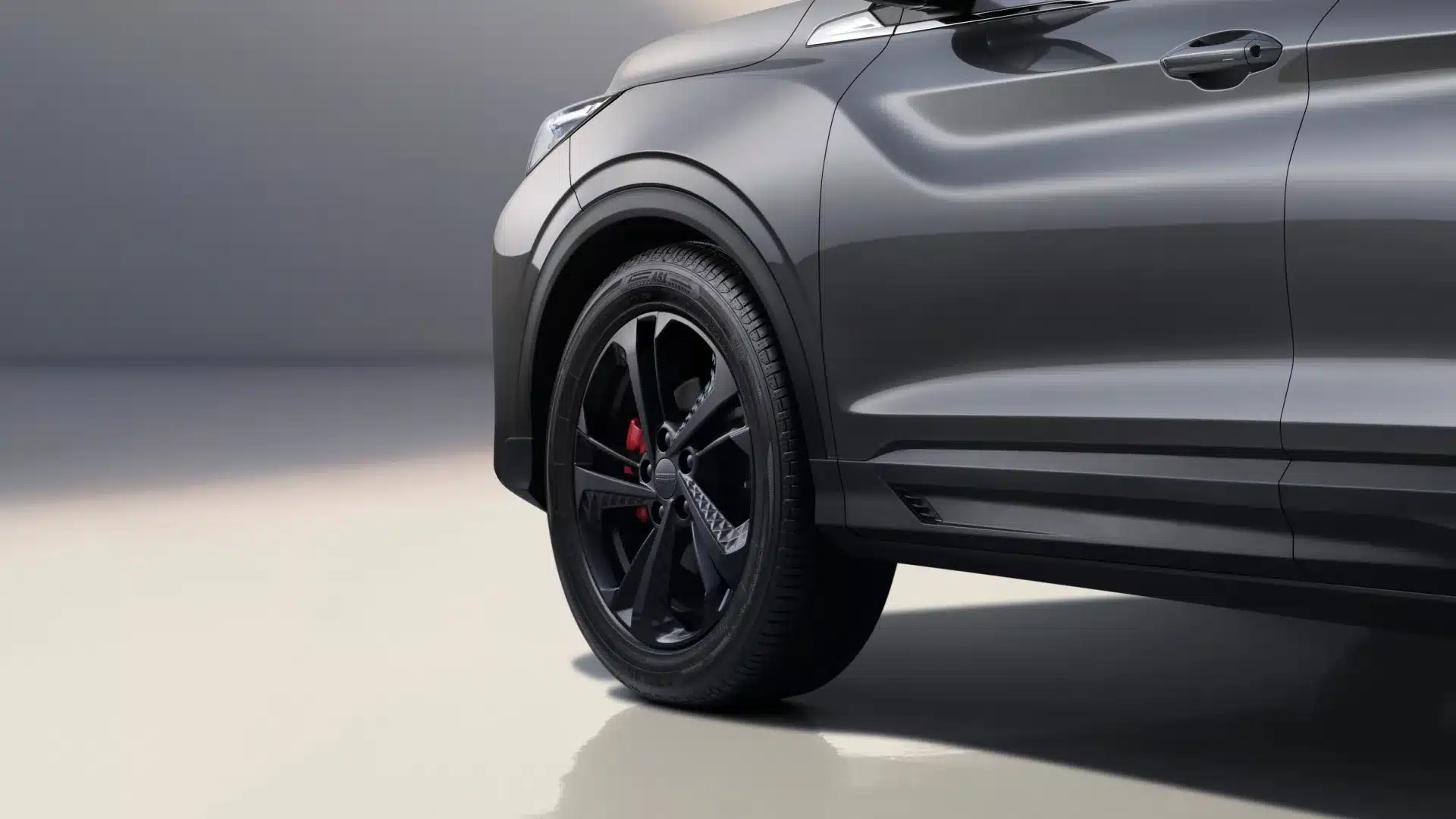 Nahaufnahme der vorderen Seitenpartie und der 18-Zoll-Räder im Battle Axe-Design mit roten Bremssätteln beim Geely Coolray