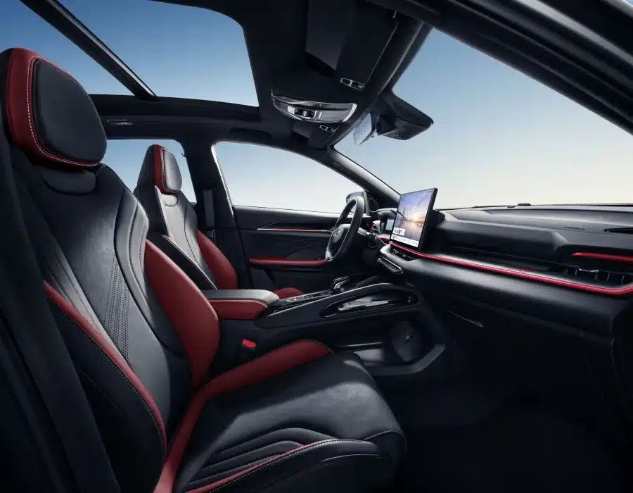 Innenraum des Geely Coolray mit roten Akzenten, Infotainmentsystem und Panoramadach.