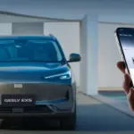Frontansicht des elektrischen SUVs Geely EX5, daneben ein Smartphone mit Fahrzeug-App.