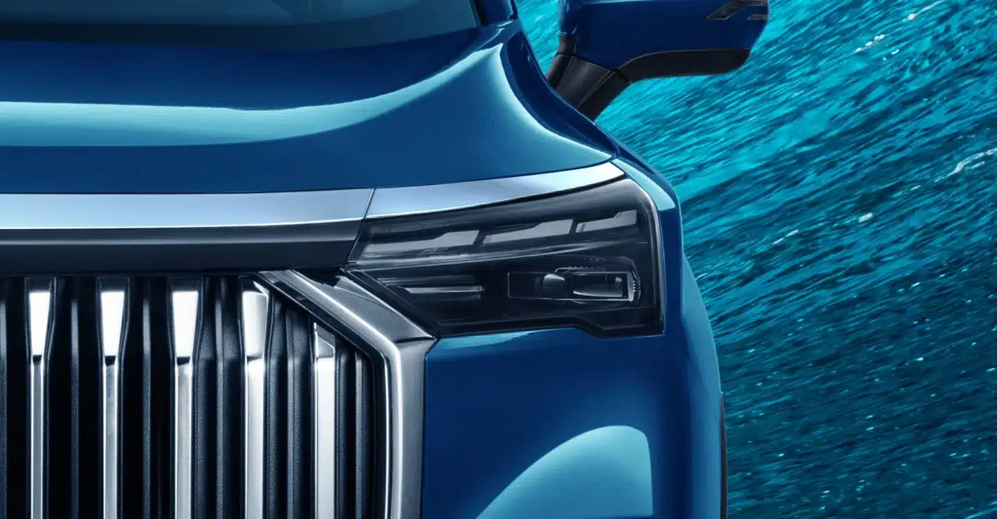 Nahaufnahme von Kühlergrill und Scheinwerfer des Geely Okavango in Blau