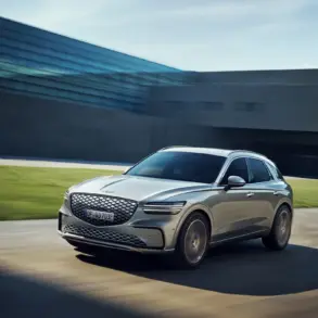 Genesis Electrified GV70 fährt dynamisch vor moderner Kulisse.