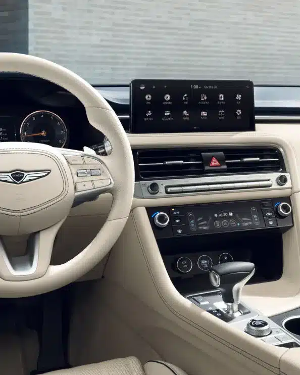 Innenraum des Genesis G70 mit modernem Multifunktionslenkrad, Digitalanzeige und großem Touchscreen
