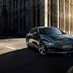 Genesis G80 Limousine fährt auf einer sonnigen Straße in der Stadt, frontal aufgenommen