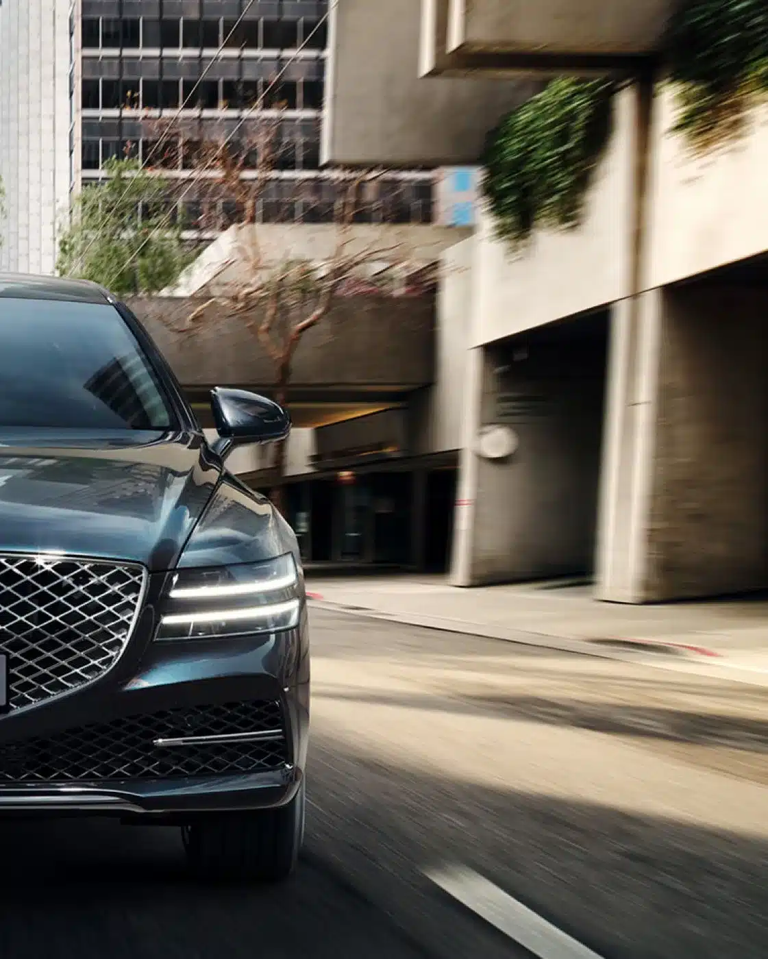 Genesis G80 Limousine von vorne in Bewegung auf einer urbanen Straße.