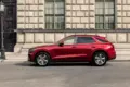 Genesis GV70 in Rot, seitlich vor einem historischen Gebäude geparkt