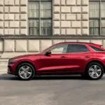 Genesis GV70 in Rot, seitlich vor einem historischen Gebäude geparkt