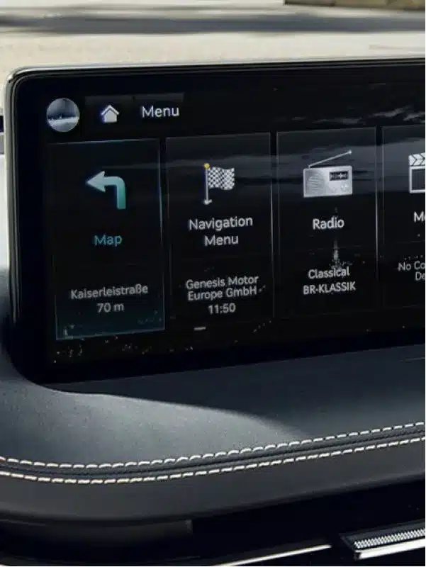 Nahaufnahme des Infotainmentsystems im Genesis GV70 mit Navigationsanzeige und Radiomenü.