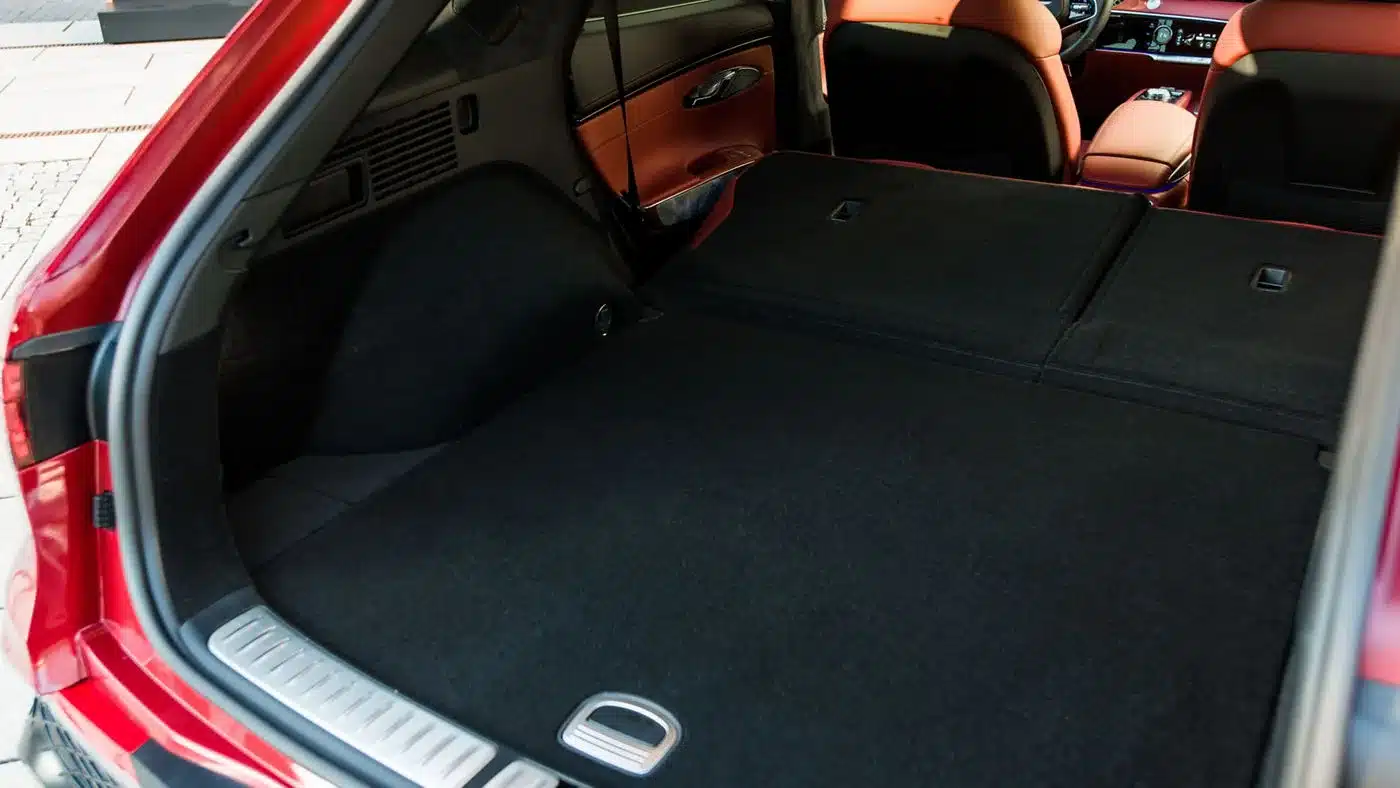 Blick in den Kofferraum des Genesis GV70 mit umgeklappten Rücksitzen und Sicht auf die Vordersitze