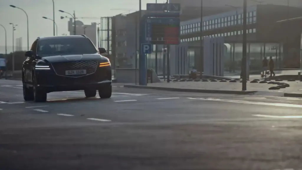 Frontale Ansicht eines Genesis GV80 auf einer urbanen Straße am Tag.