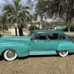 Historischer Hudson Super Six von 1947 in Türkis, Seitenansicht, mit Vier-Tür-Karosserie, weißen Reifen und Chromdetails.