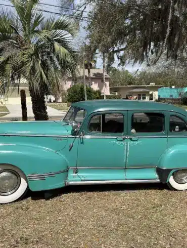 Historischer Hudson Super Six von 1947 in Türkis, Seitenansicht, mit Vier-Tür-Karosserie, weißen Reifen und Chromdetails.