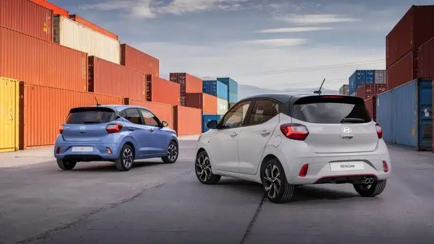 Hyundai i10 N Line und ein blaues Hyundai i10 Modell vor Containern im Freien.