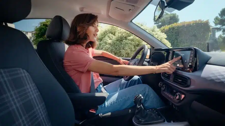 Frau bedient das Infotainmentsystem im Hyundai i10 Innenraum
