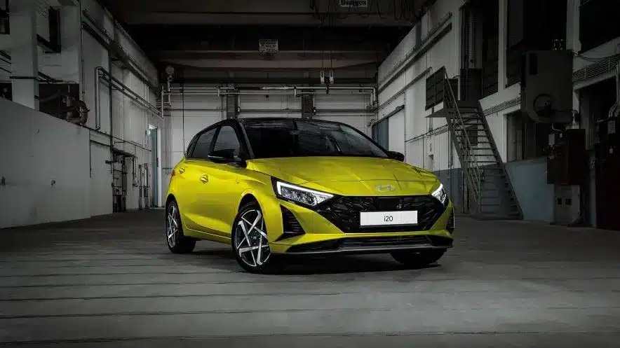 Hyundai i20 in gelber Lackierung steht in einer Industriehalle, frontal fotografiert.