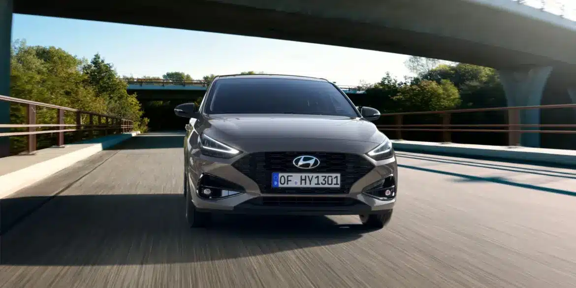 Hyundai i30 in Frontansicht fahrend auf leerer Straße unter einer Brücke