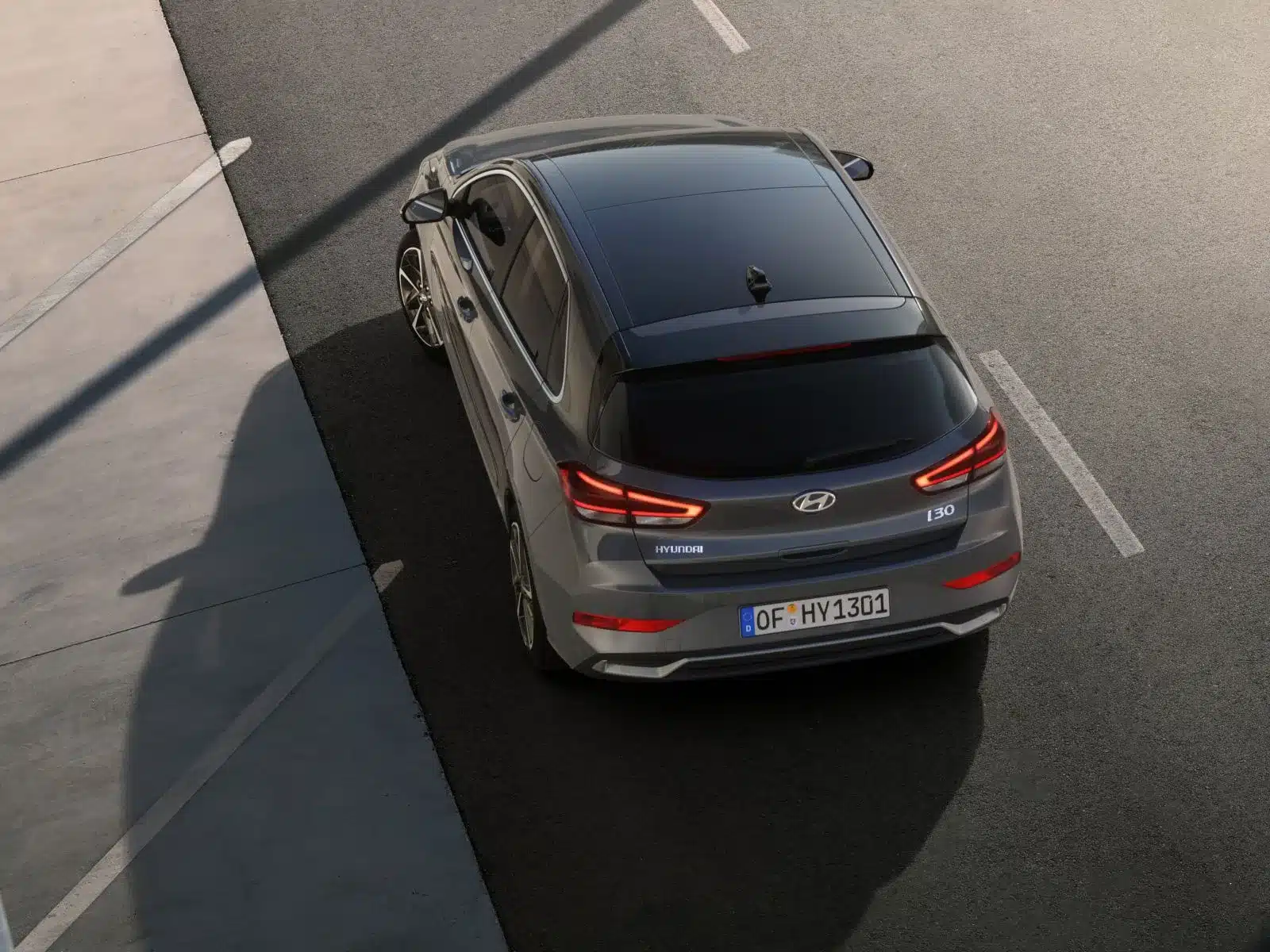 Heckansicht eines silbernen Hyundai i30 auf einem Parkplatz, modernes Design und LED-Rückleuchten
