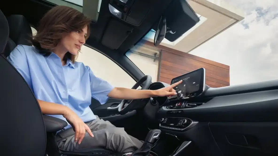 Frau bedient das digitale Cockpit und Infotainment-System im Hyundai i30.