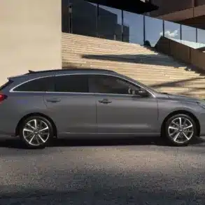 Seitenansicht des Hyundai i30 Kombi in Grau vor einem modernen Gebäude mit Treppe