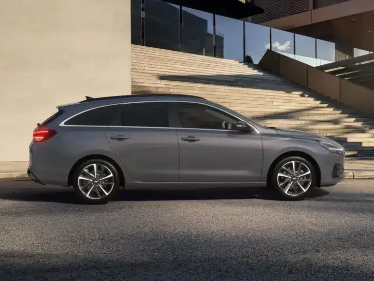 Seitenansicht des Hyundai i30 Kombi in Grau vor einem modernen Gebäude mit Treppe