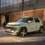 Hyundai INSTER Elektroauto steht vor einem modernen Gebäude auf einem Parkplatz.