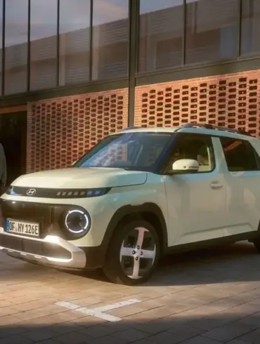 Hyundai INSTER Elektroauto steht vor einem modernen Gebäude auf einem Parkplatz.