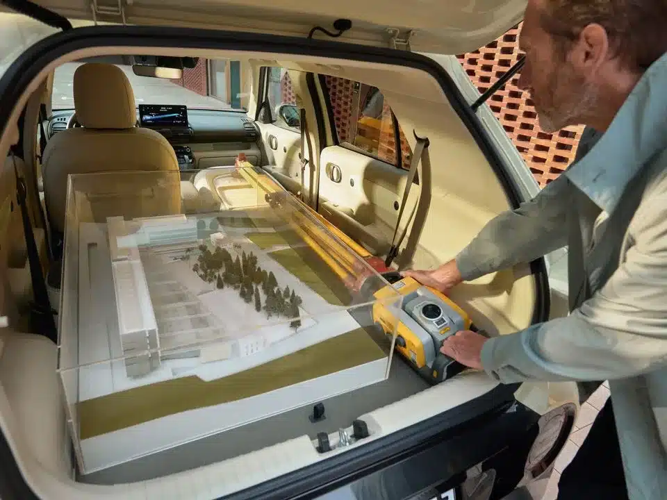 Blick in den Kofferraum eines Hyundai INSTER, in dem ein großes Architekturmodell und Werkzeug verladen sind.